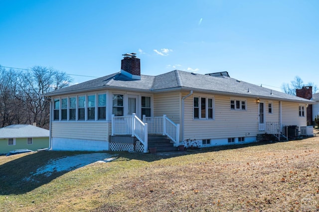 rear view of property featuring cooling unit, a yard, and a chimney