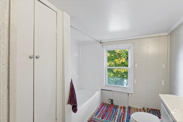 bathroom with toilet and wooden walls