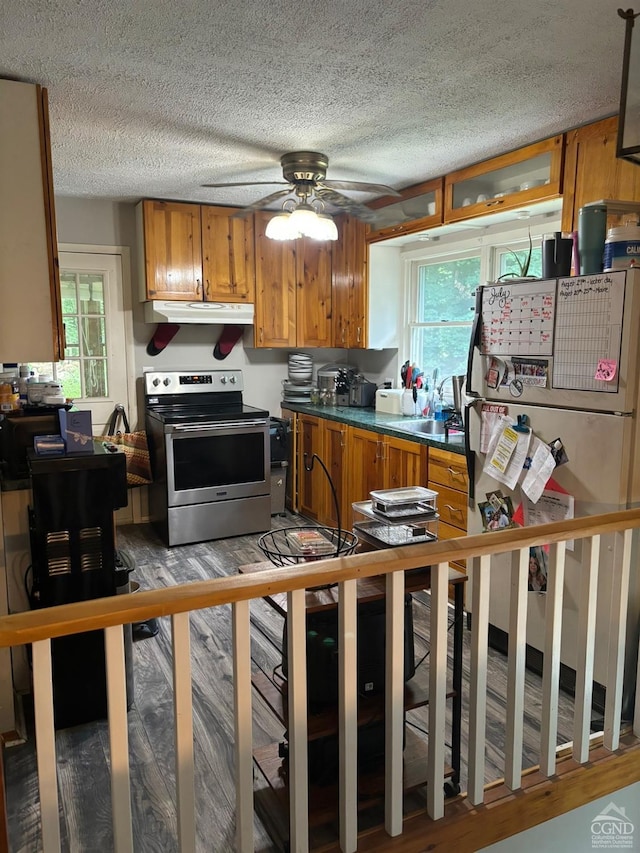 kitchen featuring ceiling fan, hardwood / wood-style floors, fridge, a textured ceiling, and stainless steel electric range