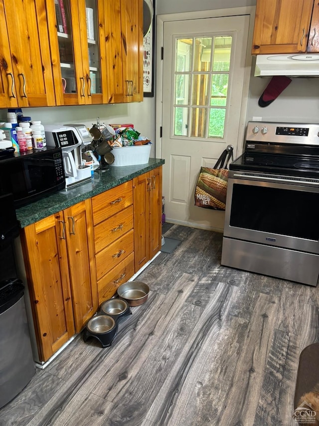 kitchen featuring dark stone counters, electric range, dark wood-type flooring, and range hood