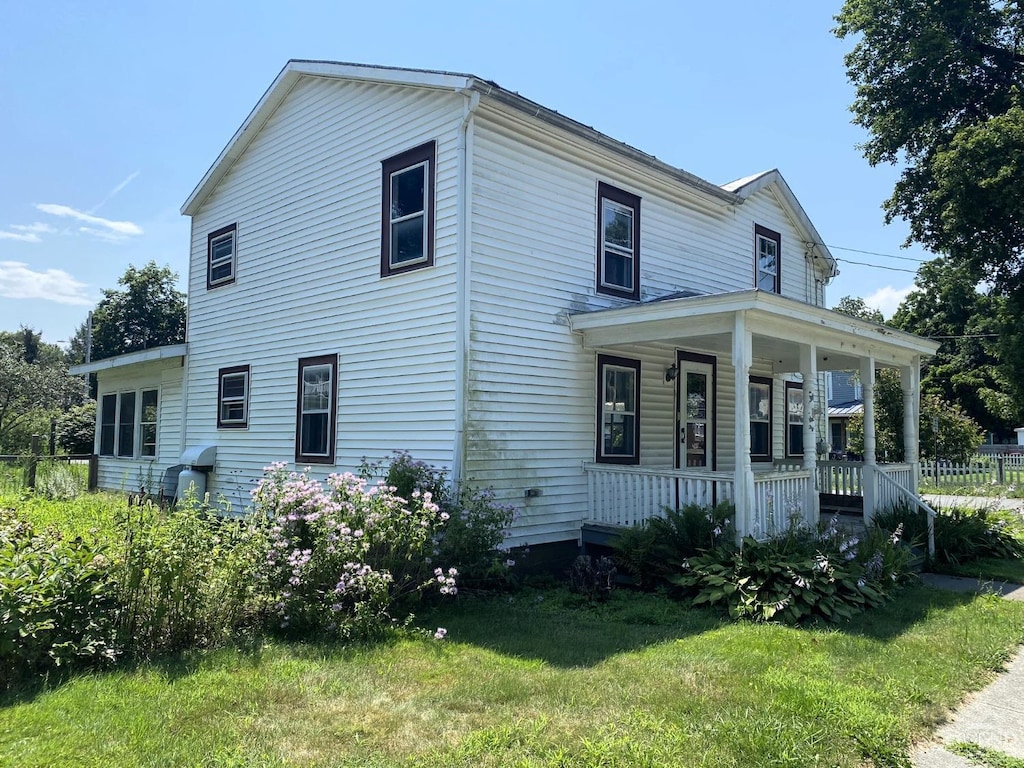 view of front of house featuring covered porch and a front lawn