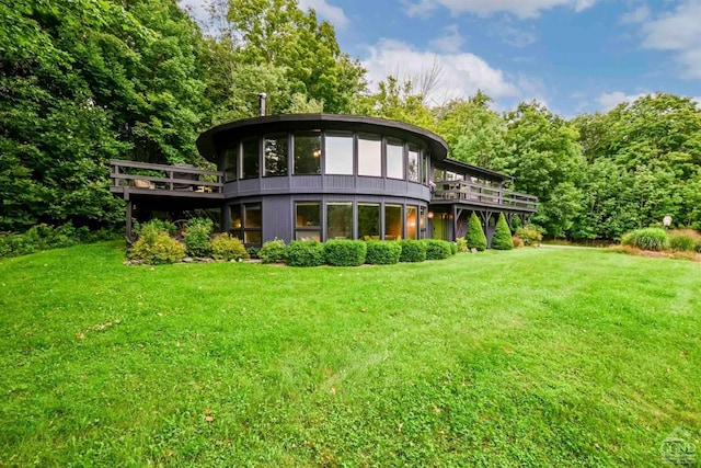 rear view of house with a yard and a deck