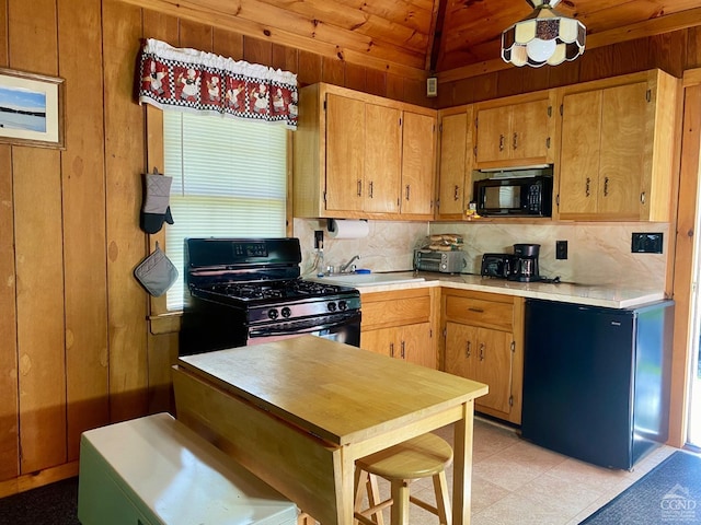 kitchen featuring range with gas stovetop, wooden walls, refrigerator, tasteful backsplash, and sink