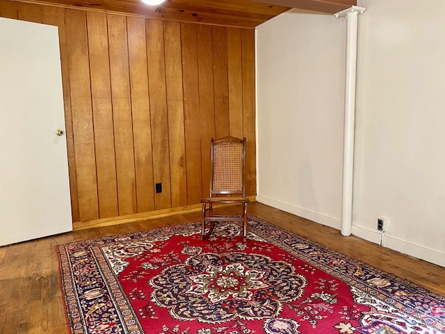 living area with hardwood / wood-style flooring, ornate columns, wood ceiling, and wood walls