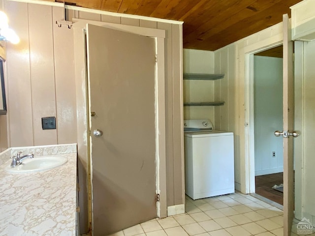 bathroom with wood ceiling, sink, washer / clothes dryer, and tile patterned flooring