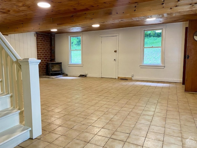 interior space with a wood stove and wooden ceiling