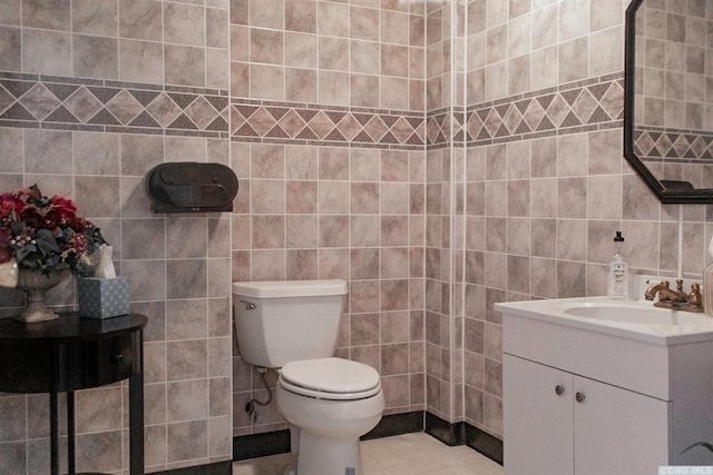 bathroom with tile patterned flooring, vanity, tile walls, and toilet