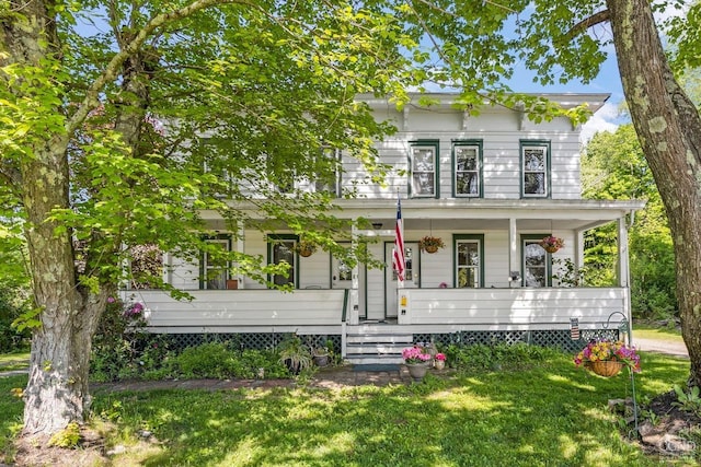 italianate-style house featuring covered porch and a front yard