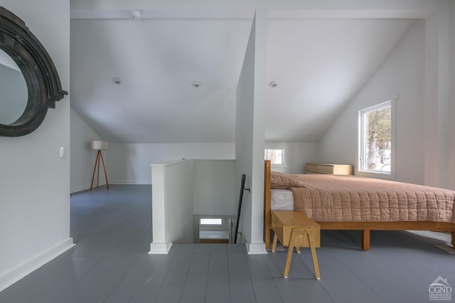 bedroom with lofted ceiling and baseboards