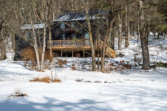 yard covered in snow with stairs and a wooden deck