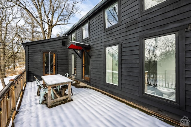 snow covered deck featuring outdoor dining space