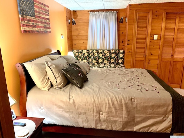 bedroom featuring wooden walls