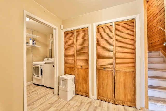 clothes washing area with light wood-type flooring and washing machine and clothes dryer