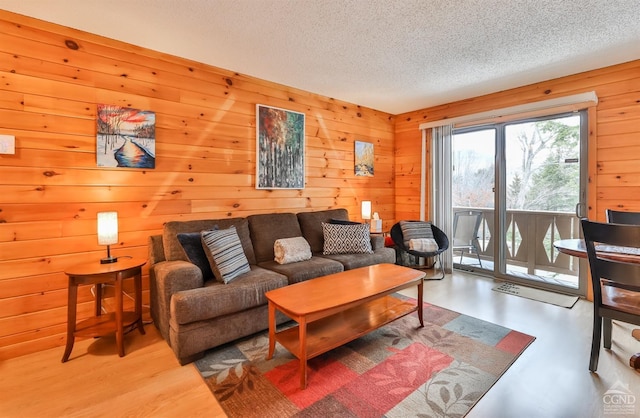 living room with a textured ceiling and wooden walls