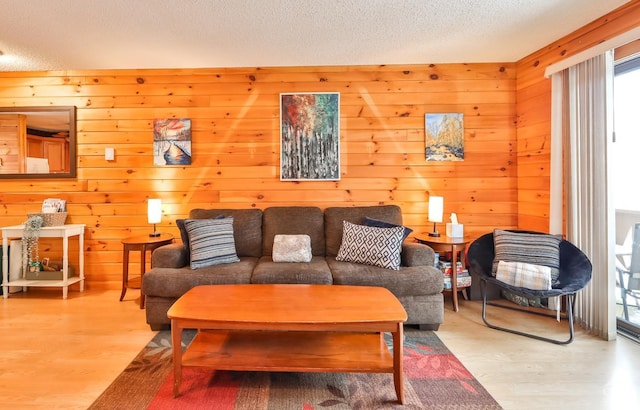 living room featuring hardwood / wood-style floors, a textured ceiling, and wood walls