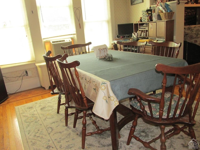 dining area featuring cooling unit and light hardwood / wood-style floors