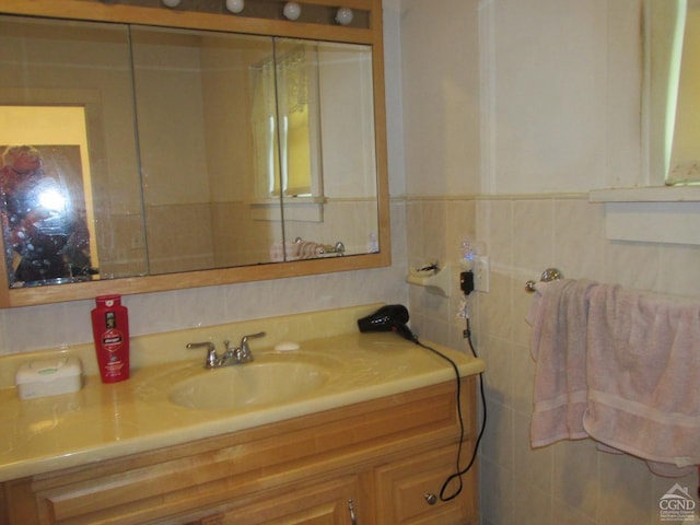 bathroom with vanity and tile walls