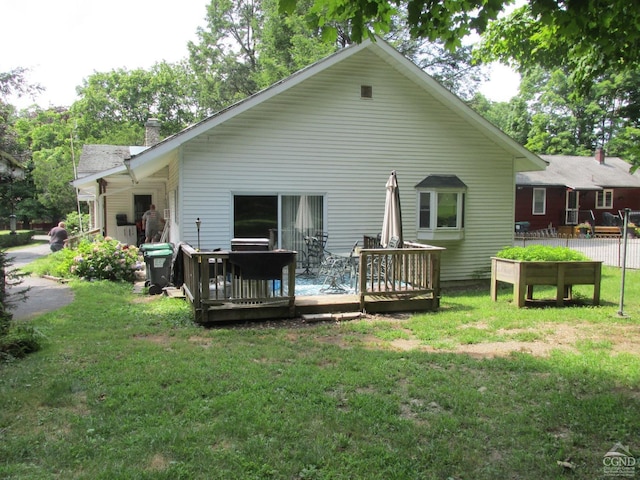 back of house featuring a yard and a deck