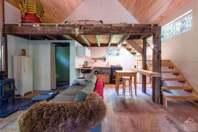 living room featuring hardwood / wood-style floors, a wood stove, a wealth of natural light, and vaulted ceiling