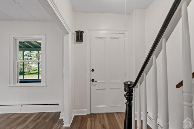 entryway with wood walls, dark hardwood / wood-style floors, and a baseboard heating unit