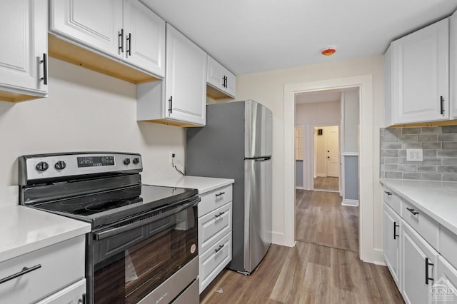 kitchen featuring light hardwood / wood-style floors, white cabinetry, backsplash, and appliances with stainless steel finishes