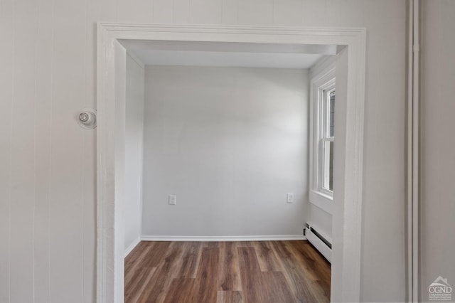 empty room featuring dark hardwood / wood-style flooring and a baseboard radiator