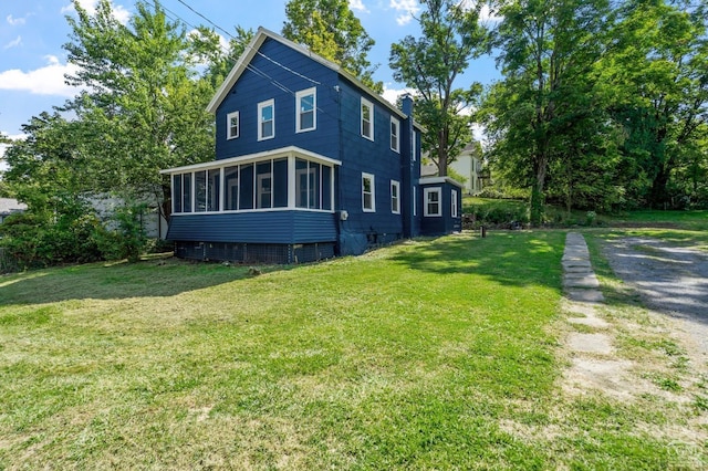 view of property exterior with a sunroom and a yard