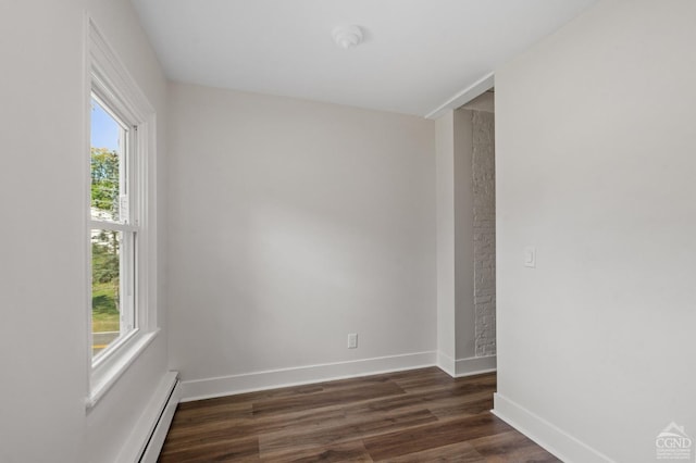 empty room featuring dark wood-type flooring and a healthy amount of sunlight