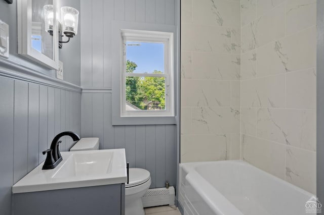 bathroom with wood walls, vanity, a baseboard radiator, and toilet