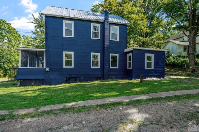 exterior space featuring a front lawn and a sunroom