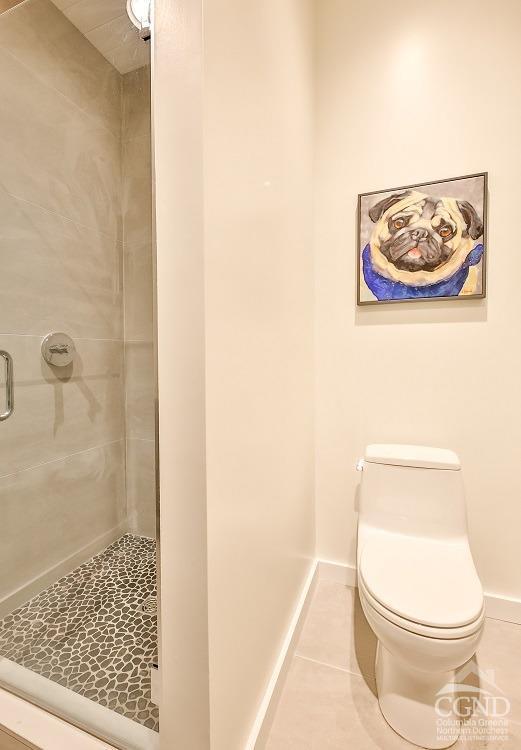 bathroom with tile patterned flooring, toilet, and walk in shower