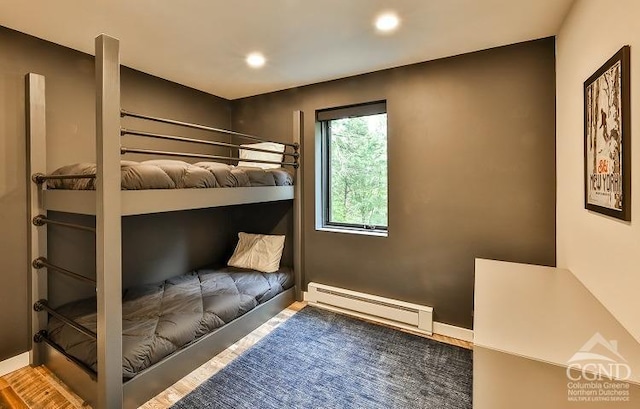 bedroom with a baseboard radiator and wood-type flooring