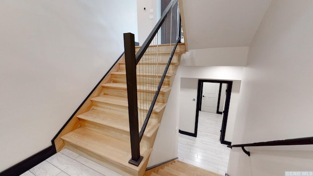 stairs with wood finished floors and baseboards