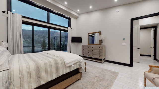 bedroom with recessed lighting, light wood-type flooring, and baseboards