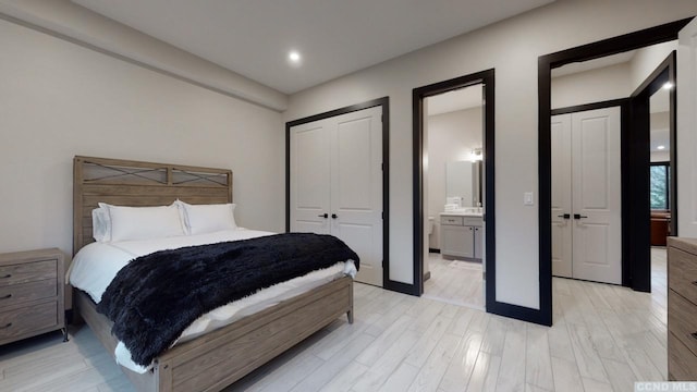 bedroom with light wood-style floors and ensuite bathroom