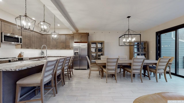 dining space featuring beam ceiling