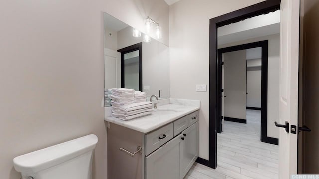 bathroom featuring toilet, wood finished floors, and vanity