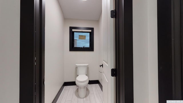 bathroom featuring toilet and baseboards