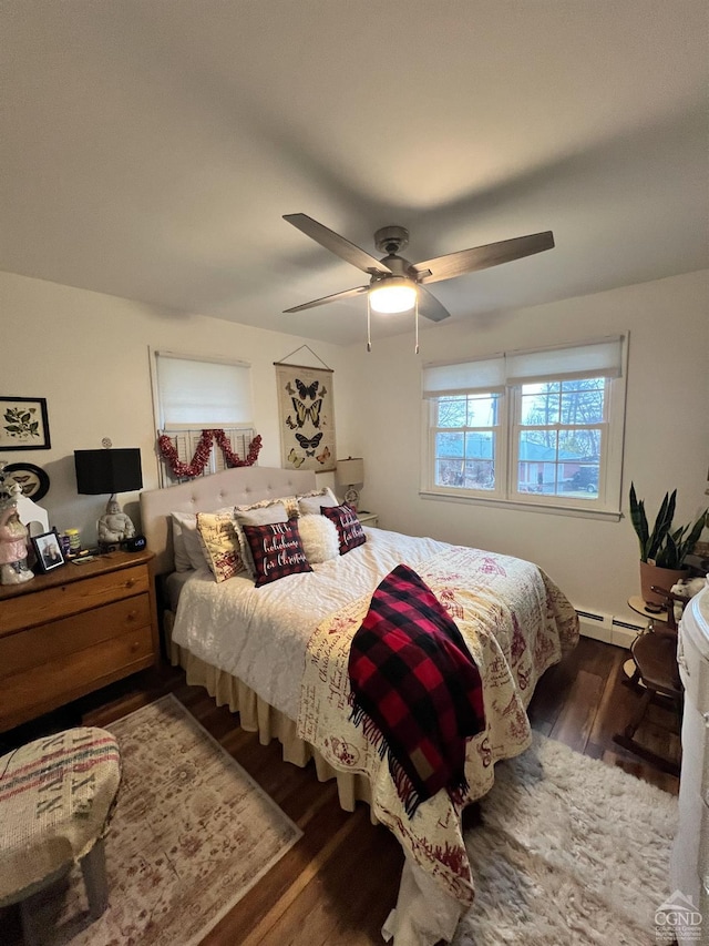 bedroom featuring ceiling fan, dark hardwood / wood-style floors, and a baseboard heating unit