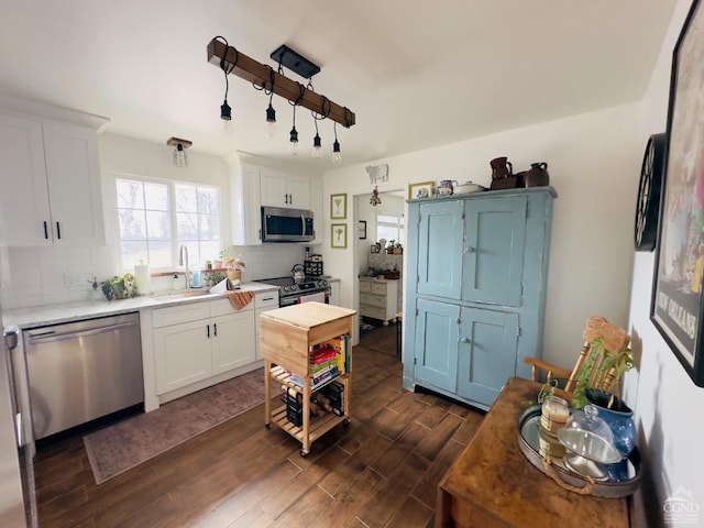 kitchen with white cabinets, decorative backsplash, sink, and appliances with stainless steel finishes