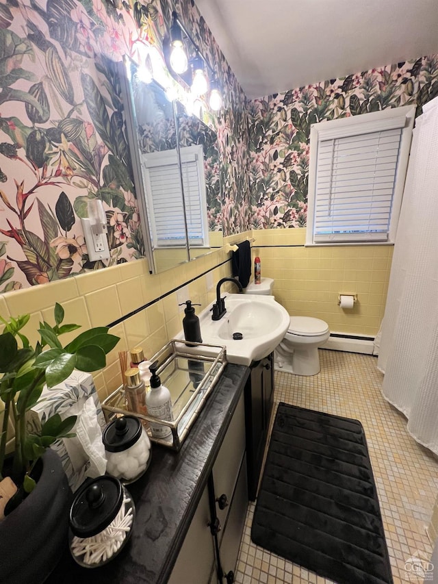 bathroom with toilet, tile patterned floors, baseboard heating, and tile walls