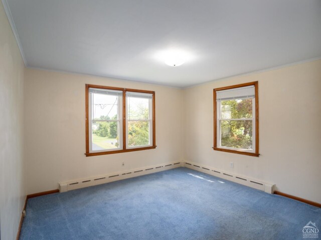 spare room featuring carpet, a baseboard heating unit, and ornamental molding