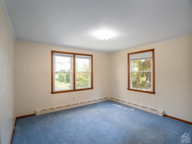 carpeted empty room with a baseboard heating unit, a wealth of natural light, and ornamental molding