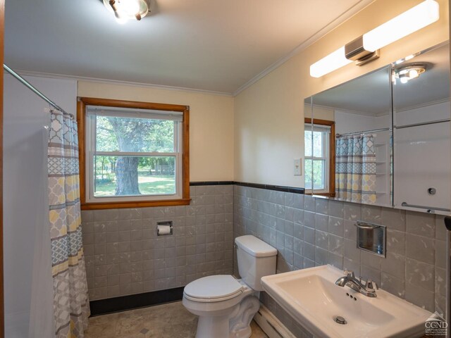 bathroom featuring crown molding, a baseboard heating unit, sink, tile walls, and toilet