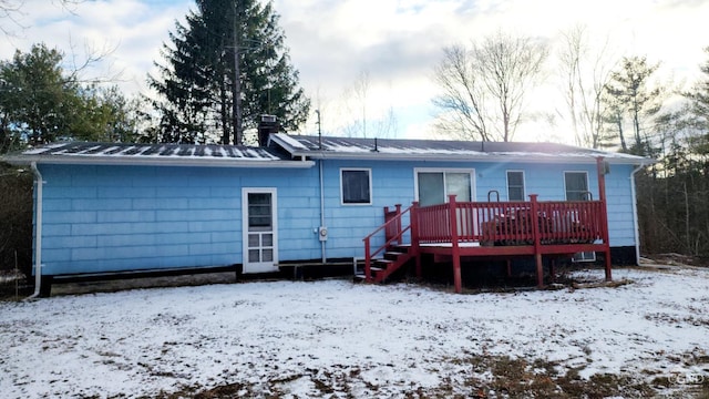 snow covered house featuring a deck