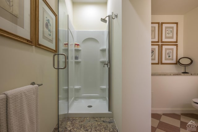 bathroom featuring toilet and a shower with shower door