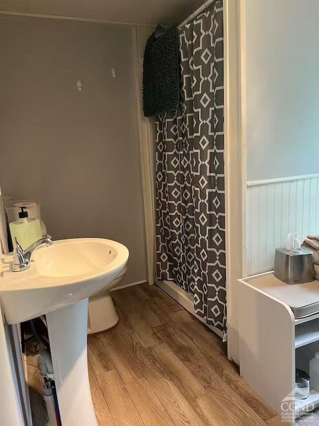 full bath featuring a shower with curtain and wood finished floors