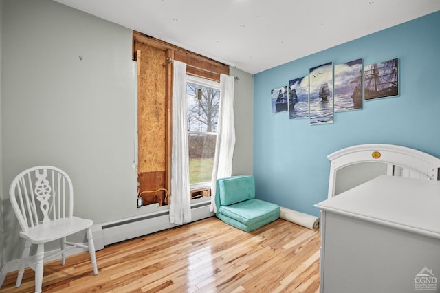 bedroom featuring a baseboard radiator and light hardwood / wood-style flooring