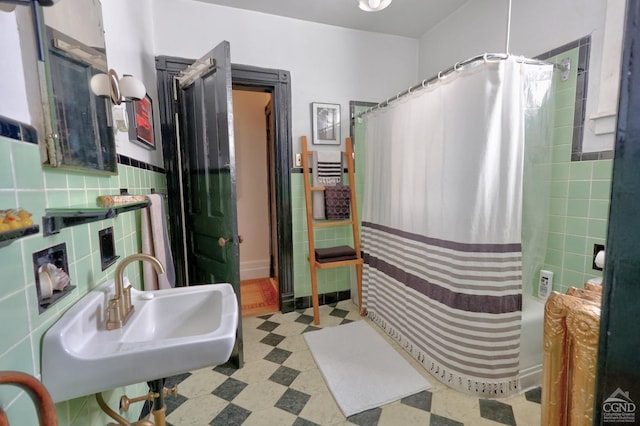 bathroom with shower / bath combination with curtain, tile walls, and sink