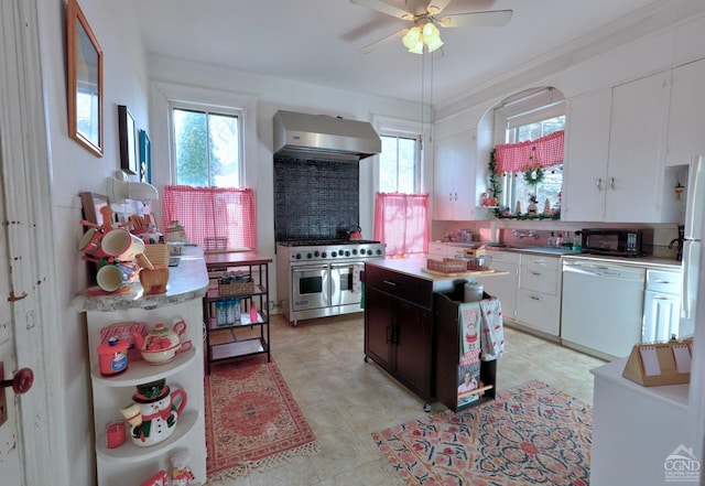 kitchen with backsplash, white appliances, wall chimney range hood, a center island, and white cabinetry